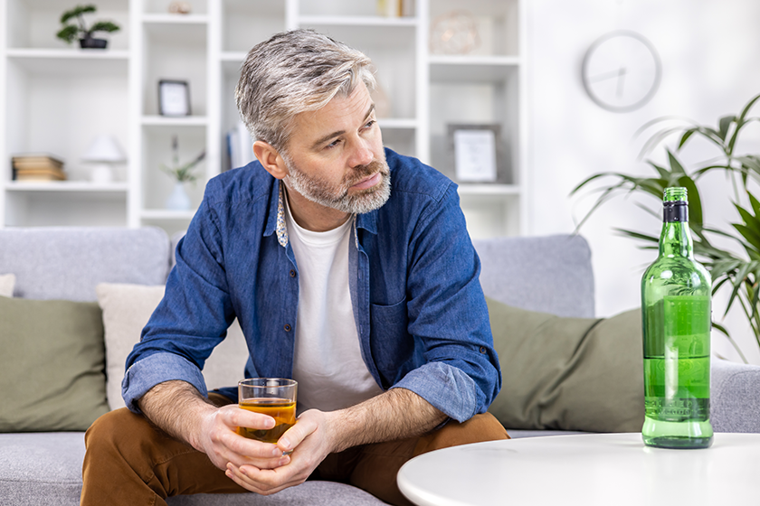 Close up of adult mature man lonely depressed drinking